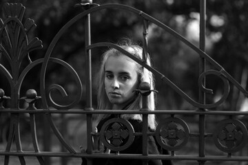 Young woman behind the fence in black and white