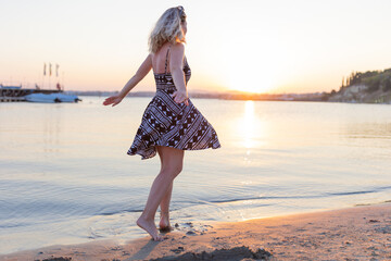 woman dancing on the beach at sunset