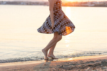 woman walking on the beach at sunset