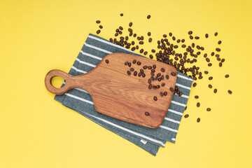 Coffee beans on wood table, isolated yellow background