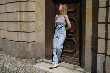 A young blonde girl in a denim jumpsuit