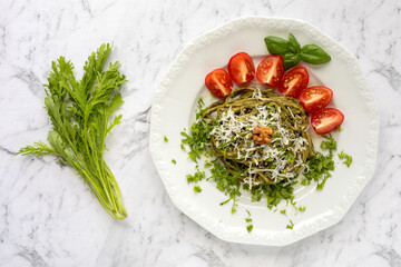 Spghetti with pesto made of mustard greens, basil and walnuts, tomatoes and basil spring, topped with chopped mustard greens. Joung mustard springs.