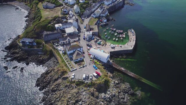 Aerial shot of Coverack fishing village , harbour and lifeboat slipway on summer day
