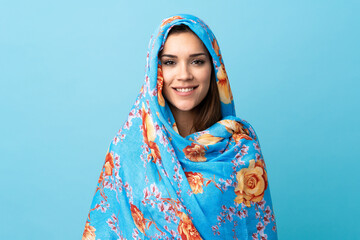 Young Moroccan woman with traditional costume isolated on blue background