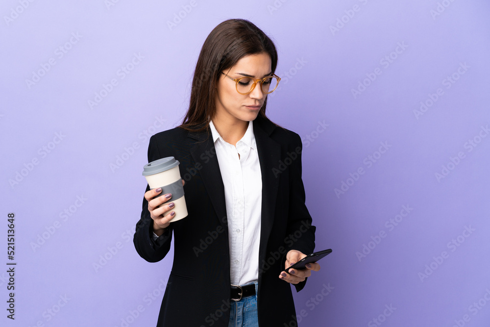 Sticker Business woman isolated on purple background holding coffee to take away and a mobile