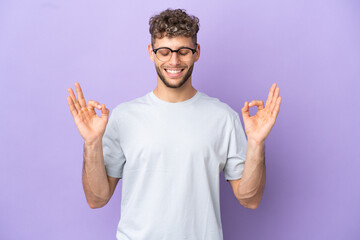 Delivery caucasian man isolated on purple background in zen pose