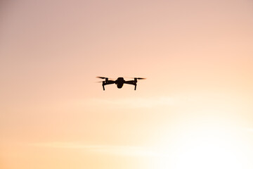 The drone is in flight at sunset . Video shooting from above. An article about the choice of a quadrocopter. Pros and cons of the drone.