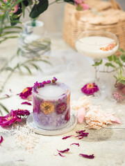 Handmade candles of a unique design, with different flowers, dry leaves on a light background....