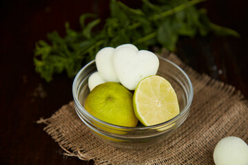 Natural marshmallows in shape of heart on sacking in glass saucer. Mint and lime decorations. Healthy eating