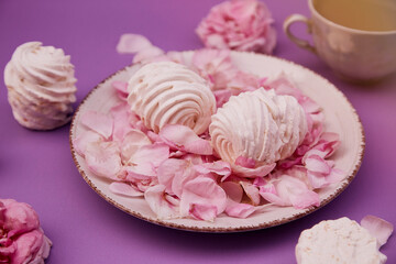 Natural vanilla sugar free marshmallows with cup of cappuccino. Healthy sweets, natural food. Romantic purple background with tea rose decorations