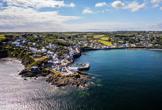 Aerial shot of Coverack fishing village , harbour and lifeboat slipway on summer day
