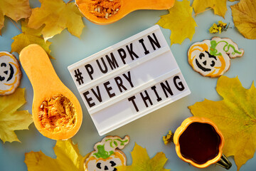 Text pumpkin everything in high modern shadows among autumn decorations and food. Orange teacup...