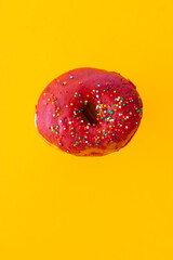 Donuts with sprinkles isolated on yellow background