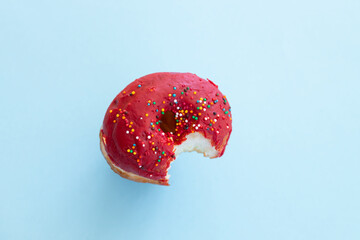 Close up donut with bite missing isolated on color background