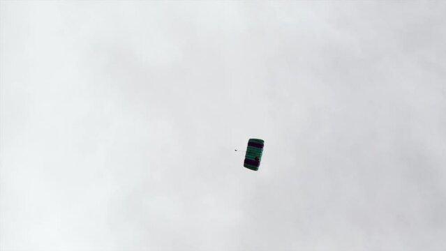 Panning A Parachutist Circling Through The Sky With A Deployed Parachute - Panama City, Panama