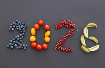 Happy New Year 2026 number made of fruits and berries on black
