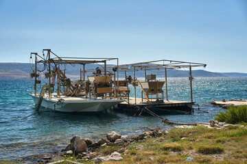 Fototapeta na wymiar Boats for growing mussels and oysters stand in the lagoon near the shore.