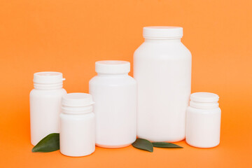 supplement pills with medicine bottle health care and medical top view. Vitamin tablets. Top view mockup bottle for pills and vitamins with green leaves, natural organic bio supplement, copy space