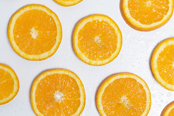 round slices of orange covered with water droplets lie on a white background. background for your design
