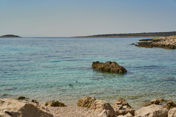 The coast of the Croatian sea with clear water and the setting sun.