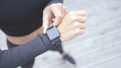 Uses a fitness watch and a tracker bracelet for calories, a runner, a female athlete does an active...