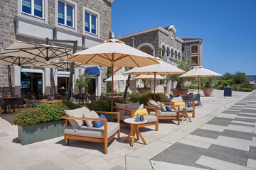Fototapeta na wymiar Cozy outdoor restaurant with sun umbrellas without people in Montenegro