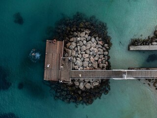 Aerial view of a jetty on rocks in the clear turquoise water of Magaluf, Majorca