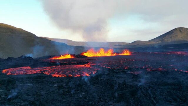 Volcanic eruption in Iceland. New Fagradalsfjall volcano eruption. Lava comes from the ground and flows to different sides. Close-up drone view of lava.