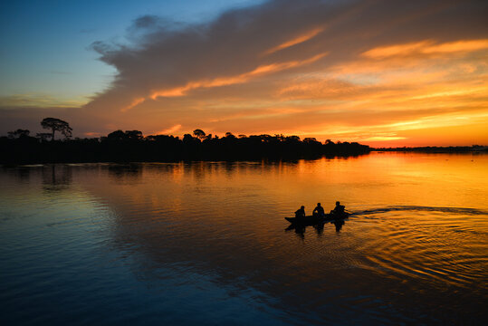 The silhouette of a small motorized canoe on the Guapor&eacute; - Itenez river at dusk, Ricardo Franco village, Vale do Guapor&eacute; Indigenous Land, Rondonia, Brazil, on the border with Bolivia