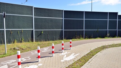 Reducing of noise and sound pollution made by transportation. Narrow road and acoustical barrier.