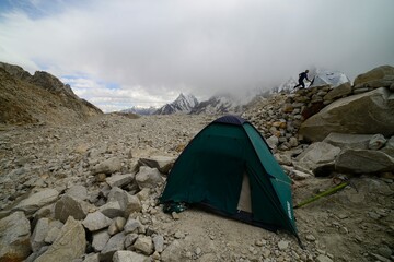 A foreign climber runs towards his tent for shelter as the storm approaches his campsite on the...