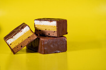 Candy made of multi-colored, puff souffle, covered with chocolate. Multi-colored, puff, sweet souffle covered with chocolate.
