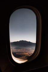 View of the mountain through the window of the plane.