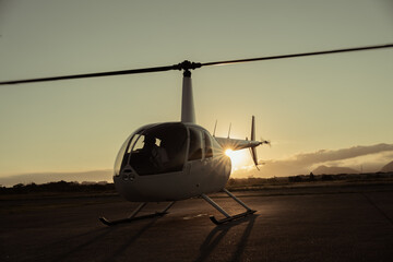 Naklejka na ściany i meble Helicopter at sunset. Airfield.