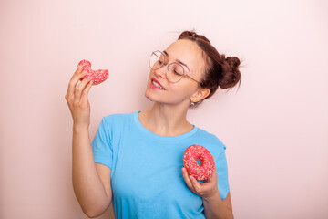 Young happy woman with fashion hairstyle holding pink donut and smiling