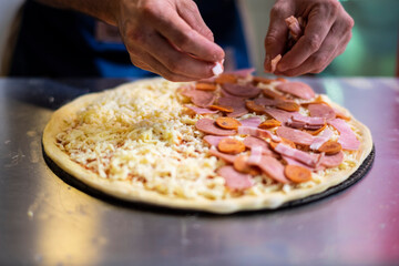 acomodando los ingredientes de una pizza