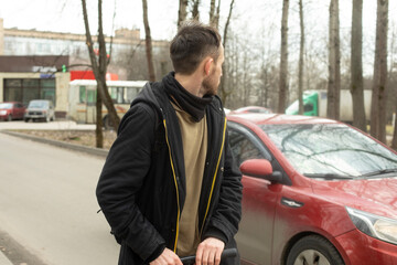 Guy in black jacket. Man on scooter.