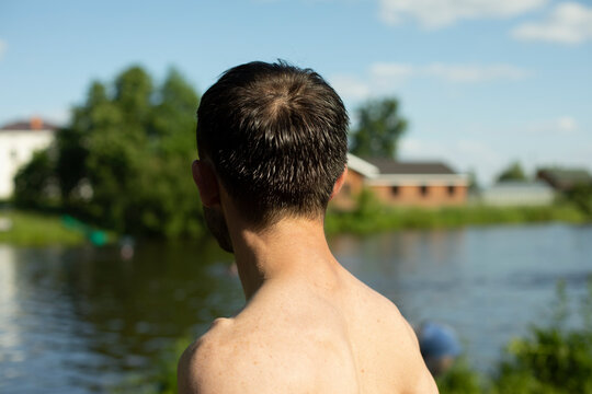 Guy Without T-shirt With Bare Back On Beach. Man Is On Vacation In Summer. Guy Sunbathes In Sun.