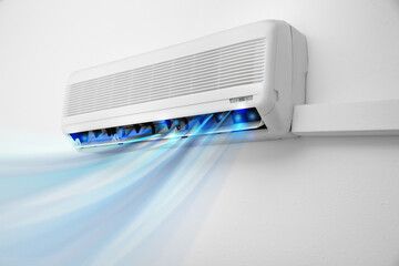Modern conditioner and illustration of cool air flow on white wall indoors