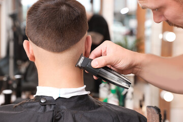 Professional hairdresser working with client in barbershop, closeup