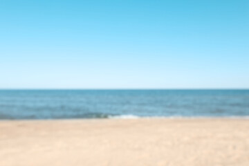 Fototapeta na wymiar Blurred view of sandy beach near sea
