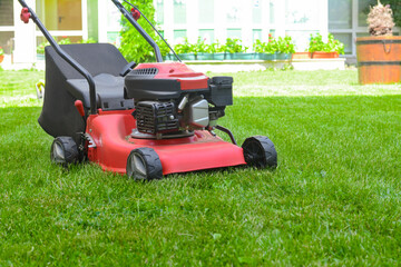 Fototapeta premium Modern garden lawn mower on green grass in park