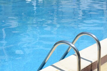 Obraz na płótnie Canvas Swimming pool with metal ladder on sunny day