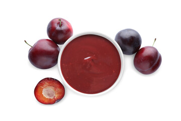 Plum puree in bowl and fresh fruits on white background, top view