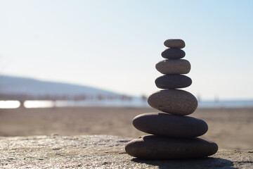 Stack of stones on parapet near sea, space for text