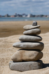 Fototapeta na wymiar Stack of stones on beautiful sandy beach near sea