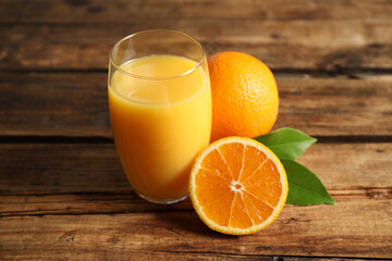 Glass of orange juice and fresh fruits on wooden table