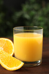Glass of orange juice and fresh fruits on wooden table, closeup