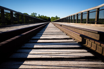 Railroad tracks close to far symmetrical, perspective view with clear blue sky at Kinzua Bridge, Pennsylvania.