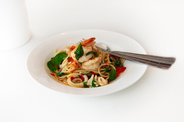 Seafood spaghetti was served on white plate.